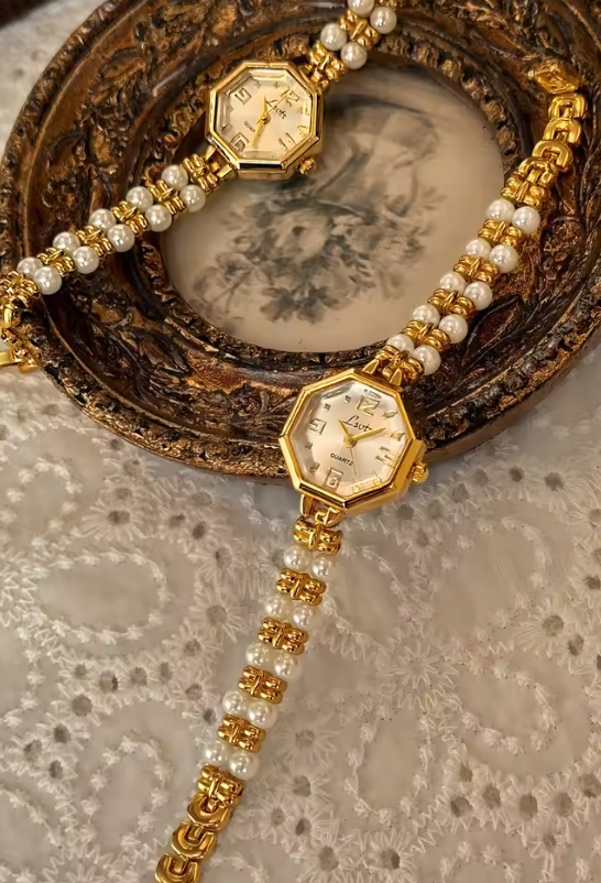 Le Belle Heure women’s gold octagonal quartz watch with pearl and gold bracelet strap on vintage surface