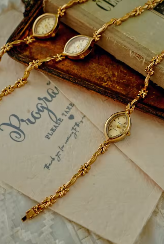Gold twisted rope and flower knot chain bracelet watch with champagne oval dial and diamond-like hour markers for women by Le Belle Heure