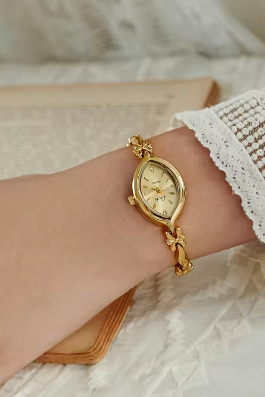 Gold twisted rope and flower knot chain bracelet watch with champagne oval dial and diamond-like hour markers for women by Le Belle Heure