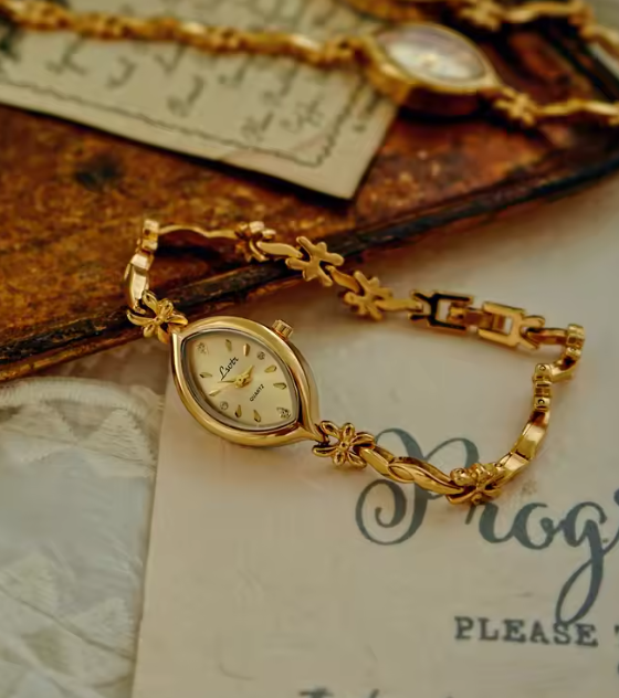 Gold twisted rope and flower knot chain bracelet watch with champagne oval dial and diamond-like hour markers for women by Le Belle Heure