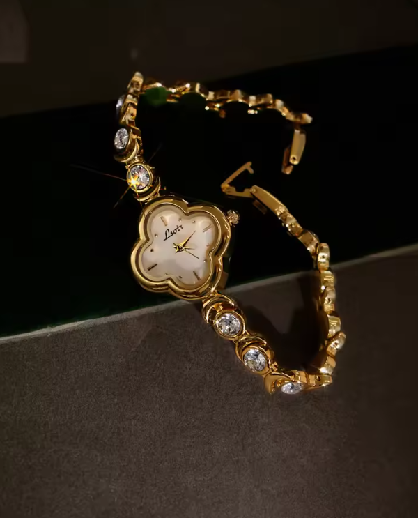 Gold four-leaf clover shaped mother-of-pearl dial quartz watch on a bezel-set round crystal tennis bracelet for women by Le Belle Heure