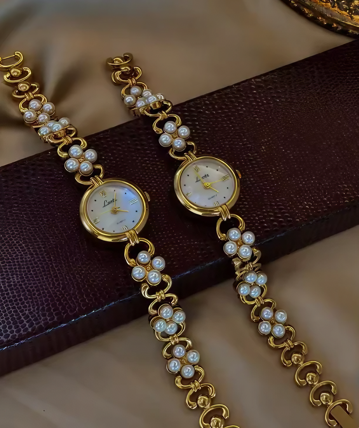 Gold oval dial ladies bracelet watch with pearl flower cluster links and Roman numerals by Le Belle Heure
