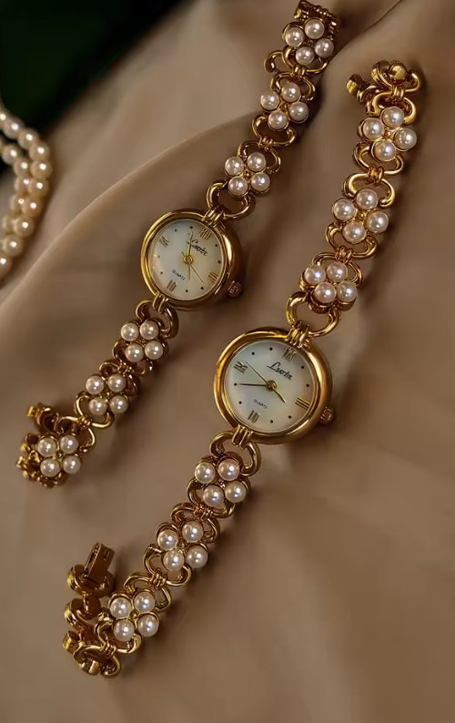 Gold oval dial ladies bracelet watch with pearl flower cluster links and Roman numerals by Le Belle Heure
