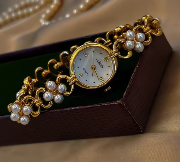 Gold oval dial ladies bracelet watch with pearl flower cluster links and Roman numerals by Le Belle Heure
