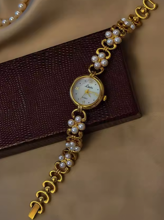 Gold oval dial ladies bracelet watch with pearl flower cluster links and Roman numerals by Le Belle Heure