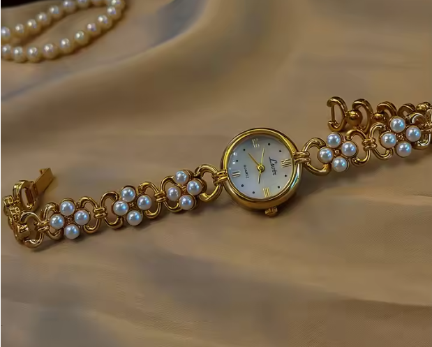 Gold oval dial ladies bracelet watch with pearl flower cluster links and Roman numerals by Le Belle Heure