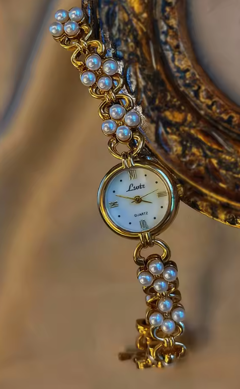 Gold oval dial ladies bracelet watch with pearl flower cluster links and Roman numerals by Le Belle Heure
