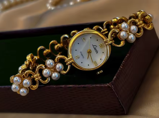 Gold oval dial ladies bracelet watch with pearl flower cluster links and Roman numerals by Le Belle Heure
