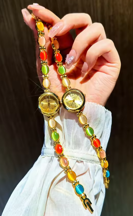 Gold-tone round dial women’s bracelet watch with multicolour peach, green and red oval gemstones by Le Belle Heure