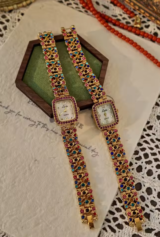 Gold-tone women’s bracelet watch with multicolour rhinestones and pink crystal bezel by Le Belle Heure
