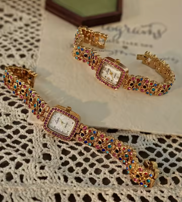 Gold-tone women’s bracelet watch with multicolour rhinestones and pink crystal bezel by Le Belle Heure