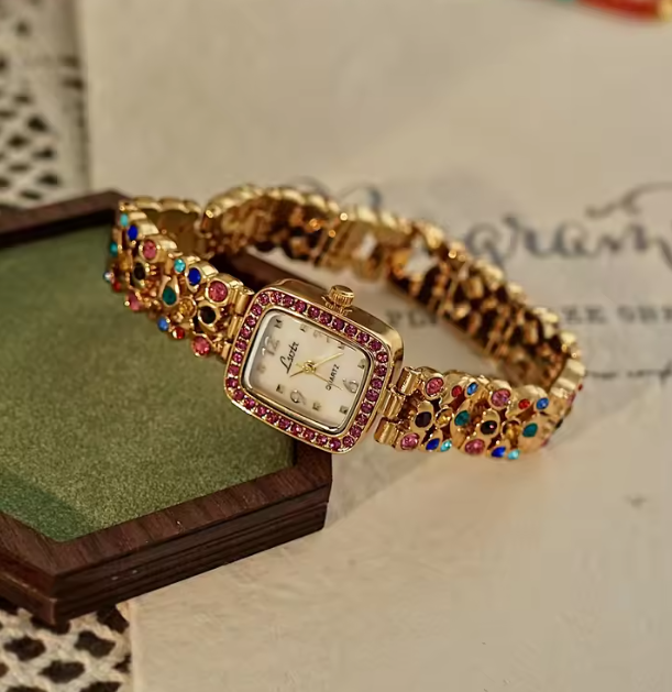 Gold-tone women’s bracelet watch with multicolour rhinestones and pink crystal bezel by Le Belle Heure