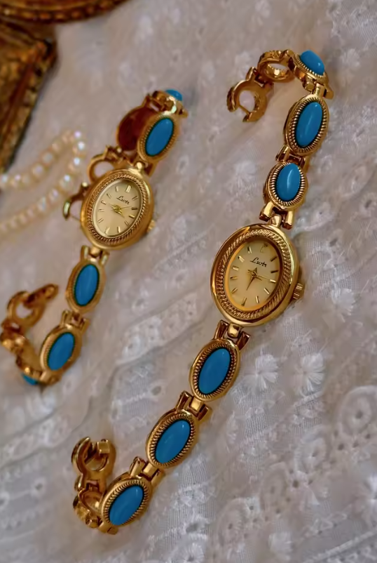 Gold rope-edge bracelet watch with vivid turquoise oval cabochon stone links and champagne oval dial for women by Le Belle Heure
