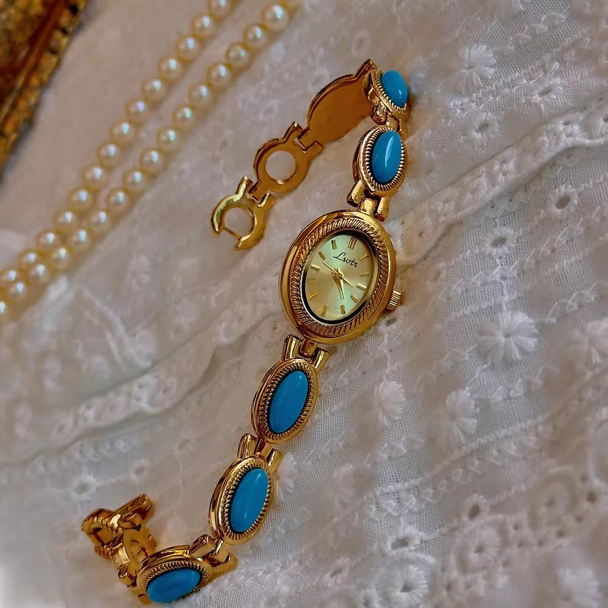 Gold rope-edge bracelet watch with vivid turquoise oval cabochon stone links and champagne oval dial for women by Le Belle Heure