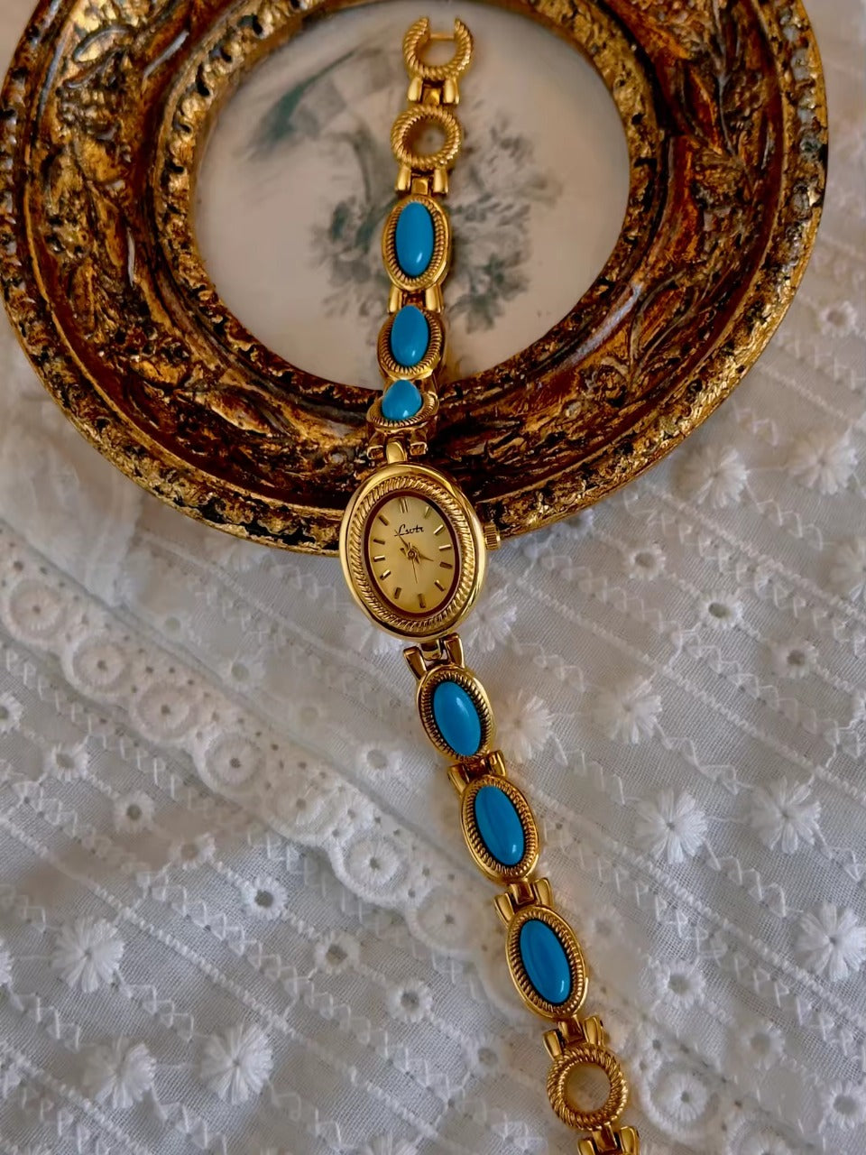 Gold rope-edge bracelet watch with vivid turquoise oval cabochon stone links and champagne oval dial for women by Le Belle Heure