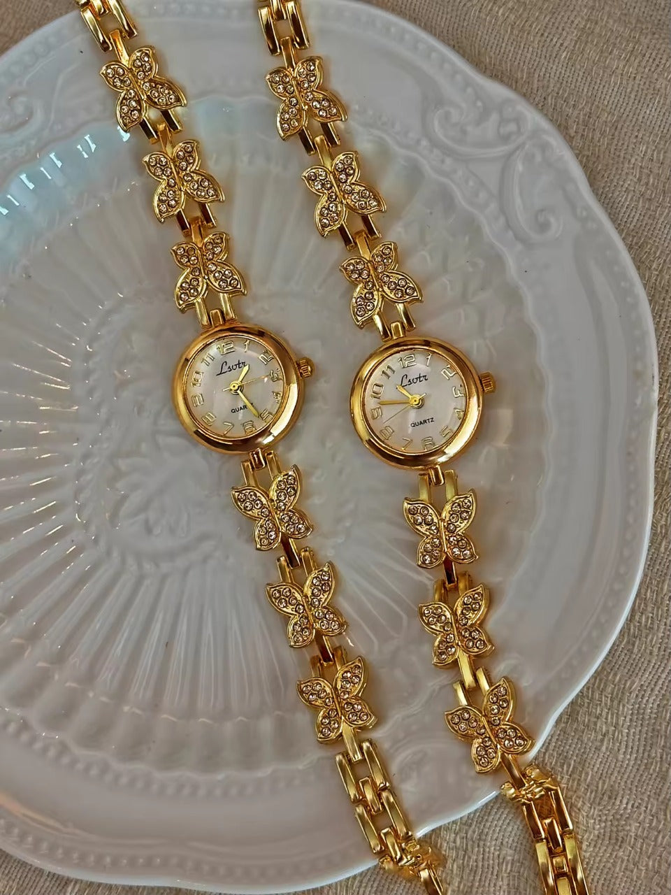 Gold crystal rhinestone butterfly link bracelet watch with mother-of-pearl round dial and Arabic numerals for women by Le Belle Heure