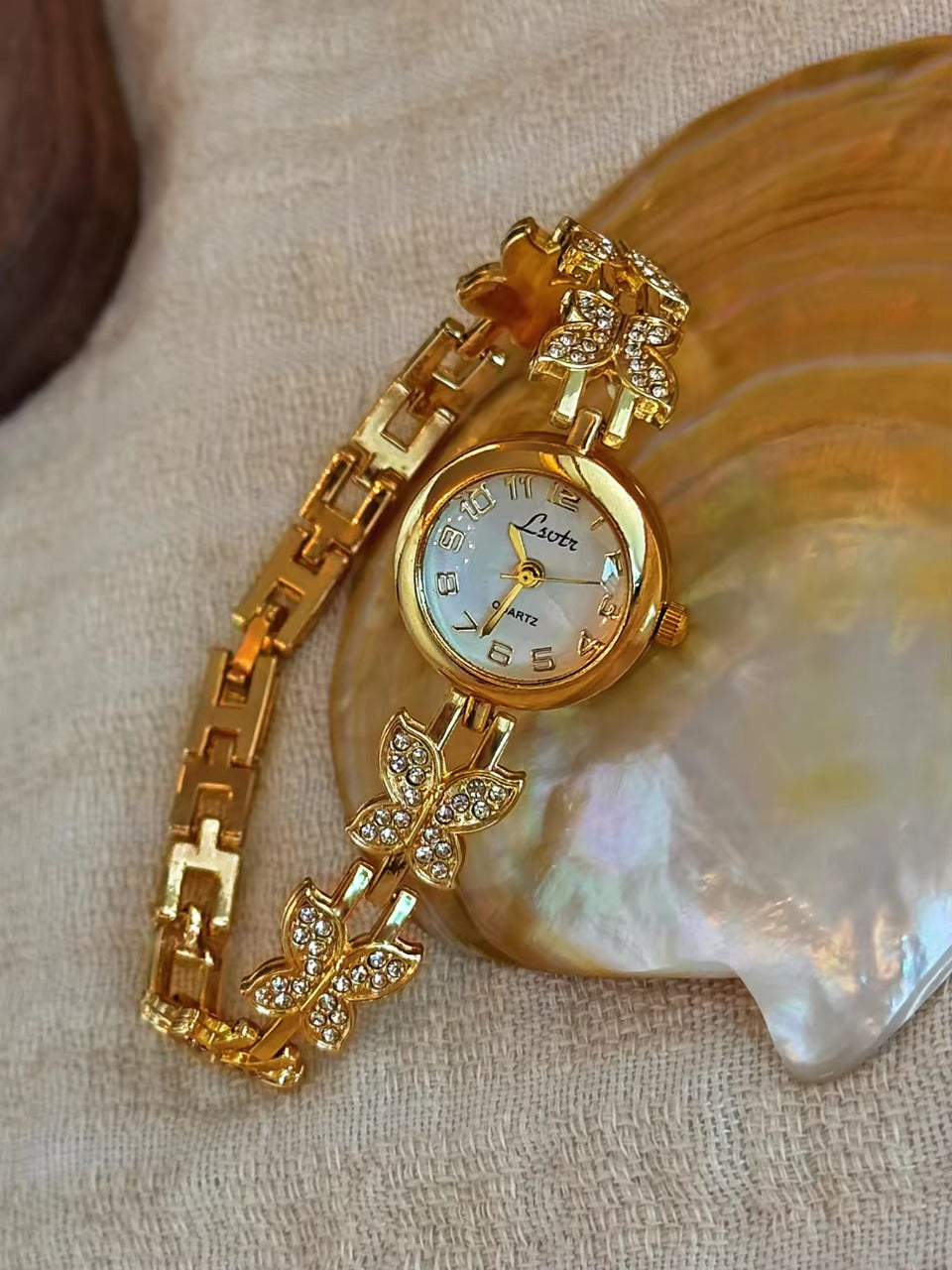 Gold crystal rhinestone butterfly link bracelet watch with mother-of-pearl round dial and Arabic numerals for women by Le Belle Heure