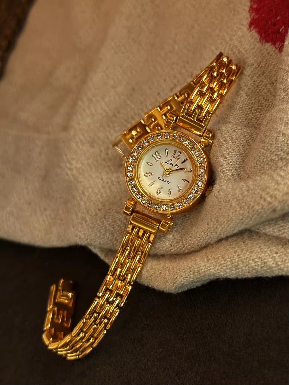Gold rhinestone halo bezel bracelet watch with white dial and
multi-row panther chain band for women by Le Belle Heure