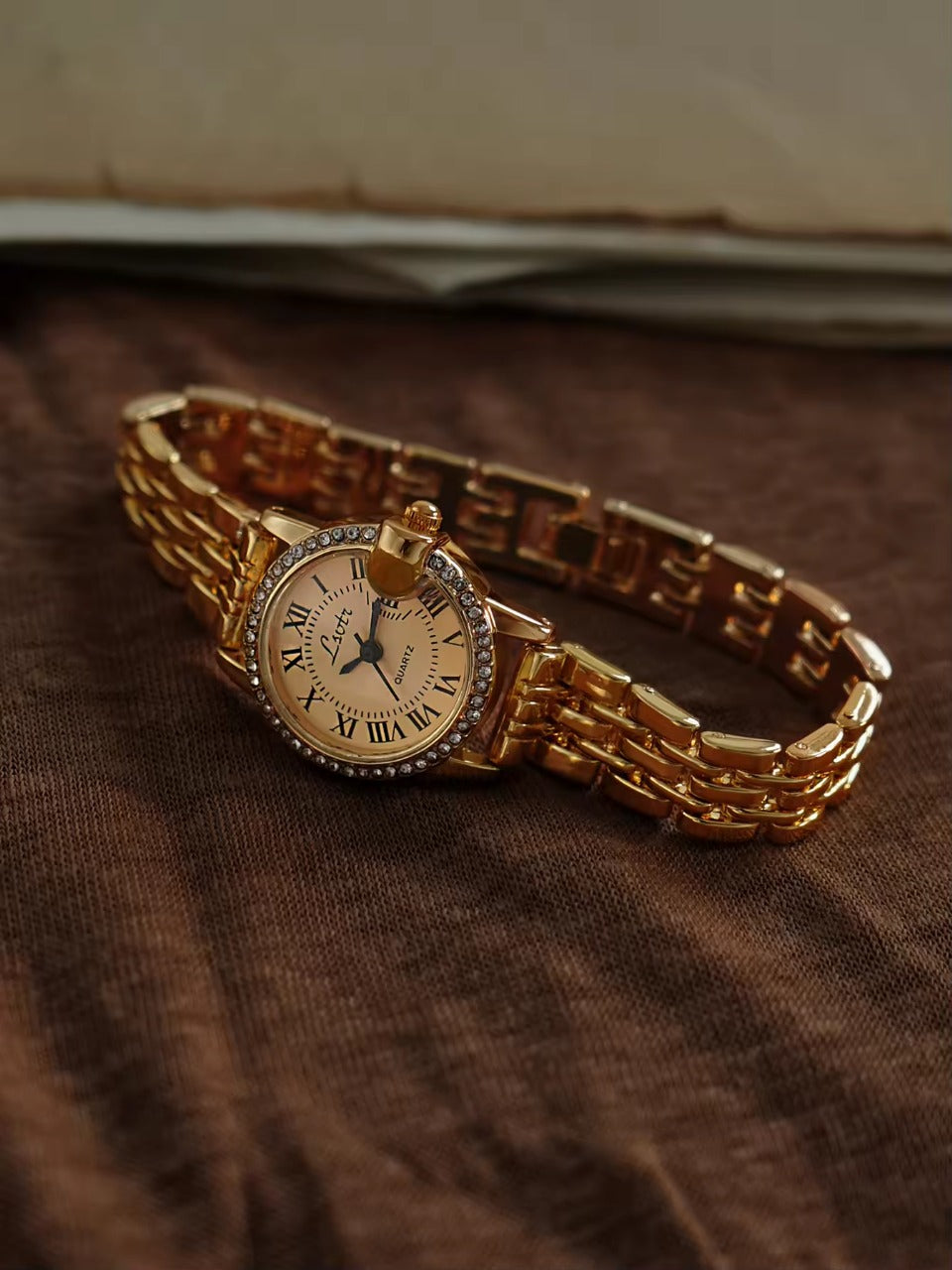 Gold ladies bracelet watch with champagne Roman numeral dial, pave
crystal halo bezel and wide multi-row panther chain by Le Belle Heure