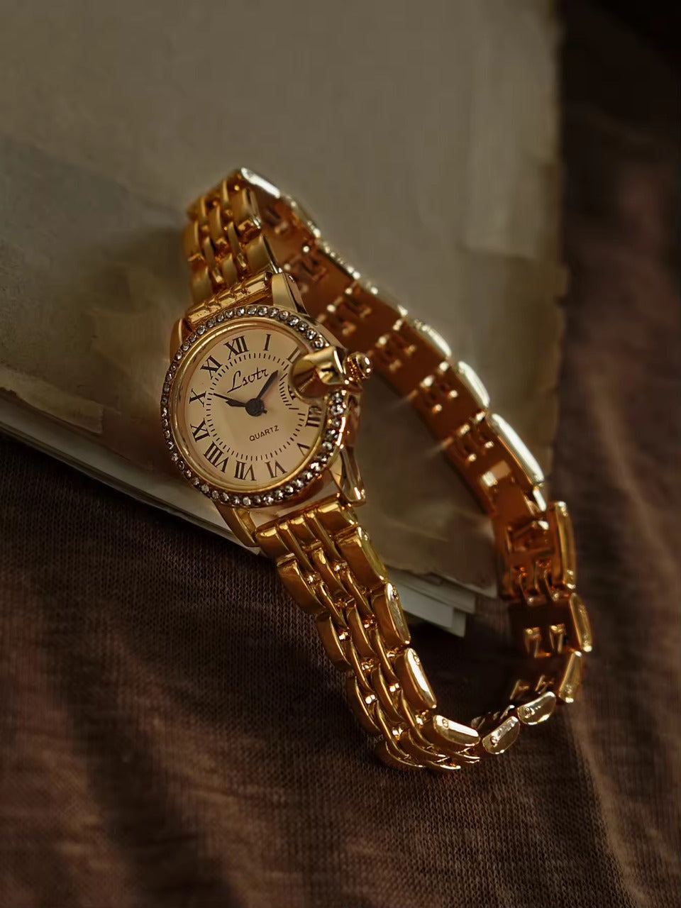 Gold ladies bracelet watch with champagne Roman numeral dial, pave
crystal halo bezel and wide multi-row panther chain by Le Belle Heure