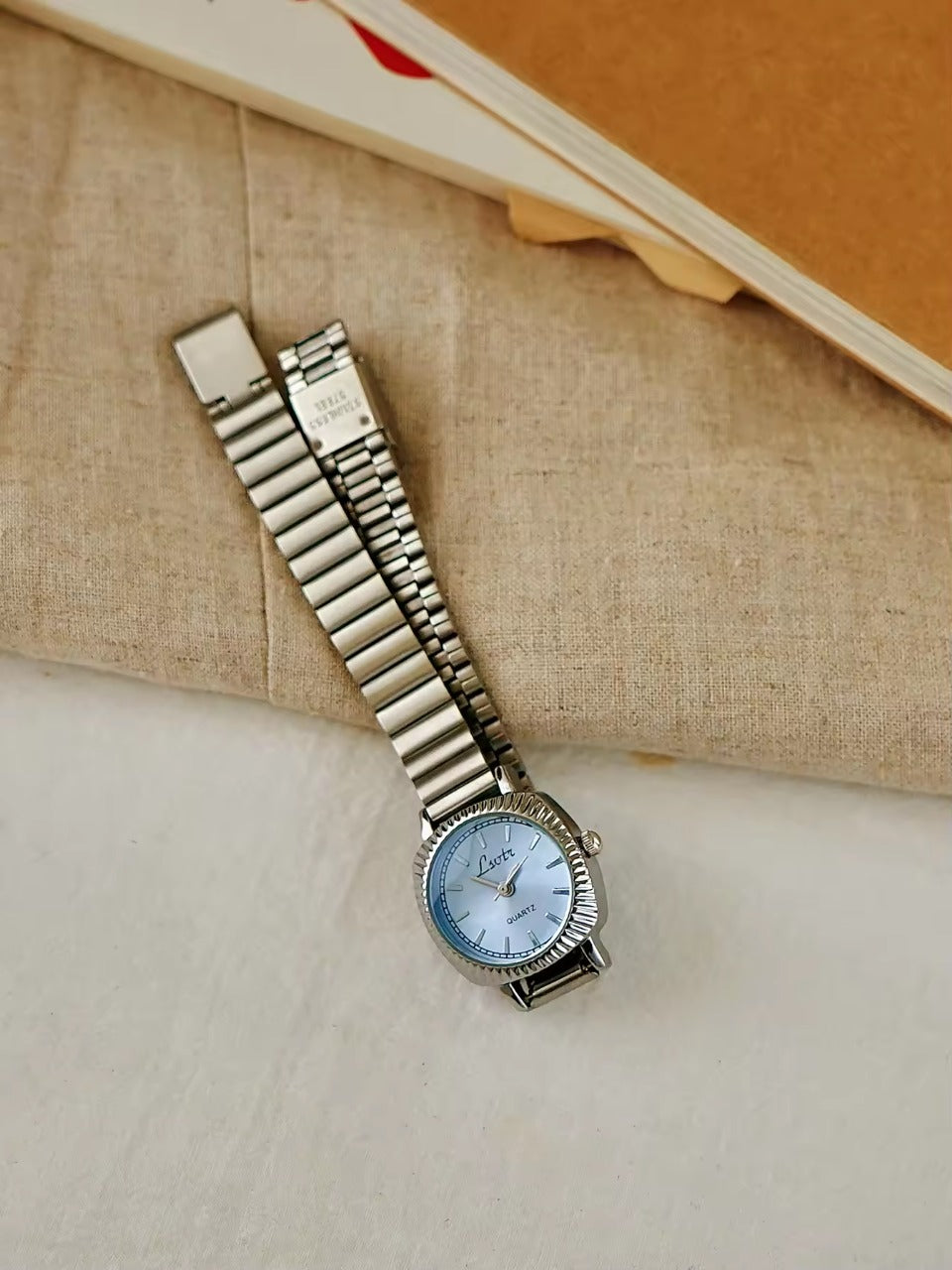 gold ribbed coin-edge bezel flex band watch with blue oval dial for women by Le Belle Heure