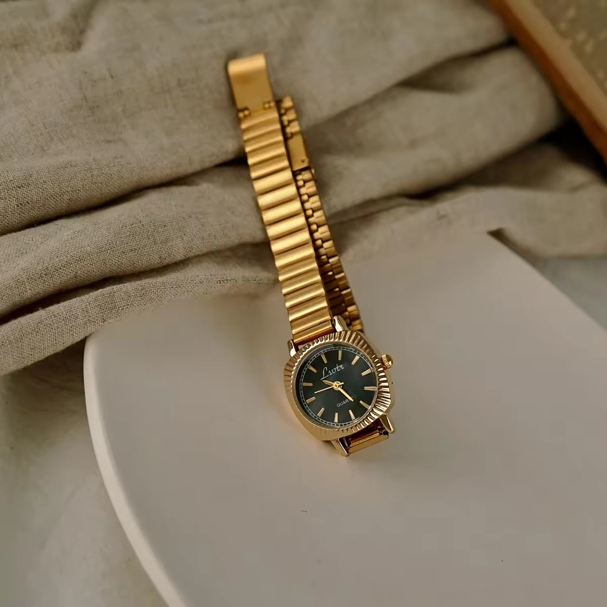gold ribbed coin-edge bezel flex band watch with black oval dial for women by Le Belle Heure
