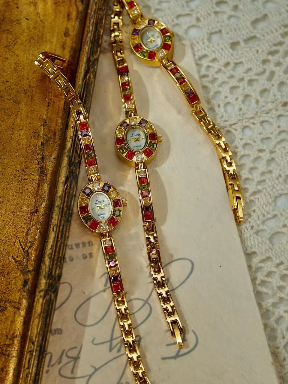 Gold oval dial ladies bracelet watch with multicolour ruby, amber, green and crystal square gemstone bezel and coloured link chain by Le Belle Heure