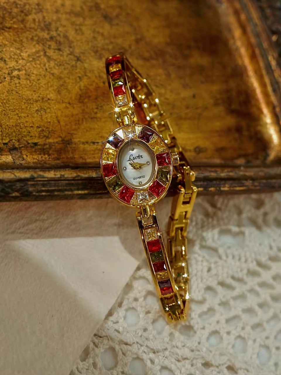 Gold oval dial ladies bracelet watch with multicolour ruby, amber, green and crystal square gemstone bezel and coloured link chain by Le Belle Heure