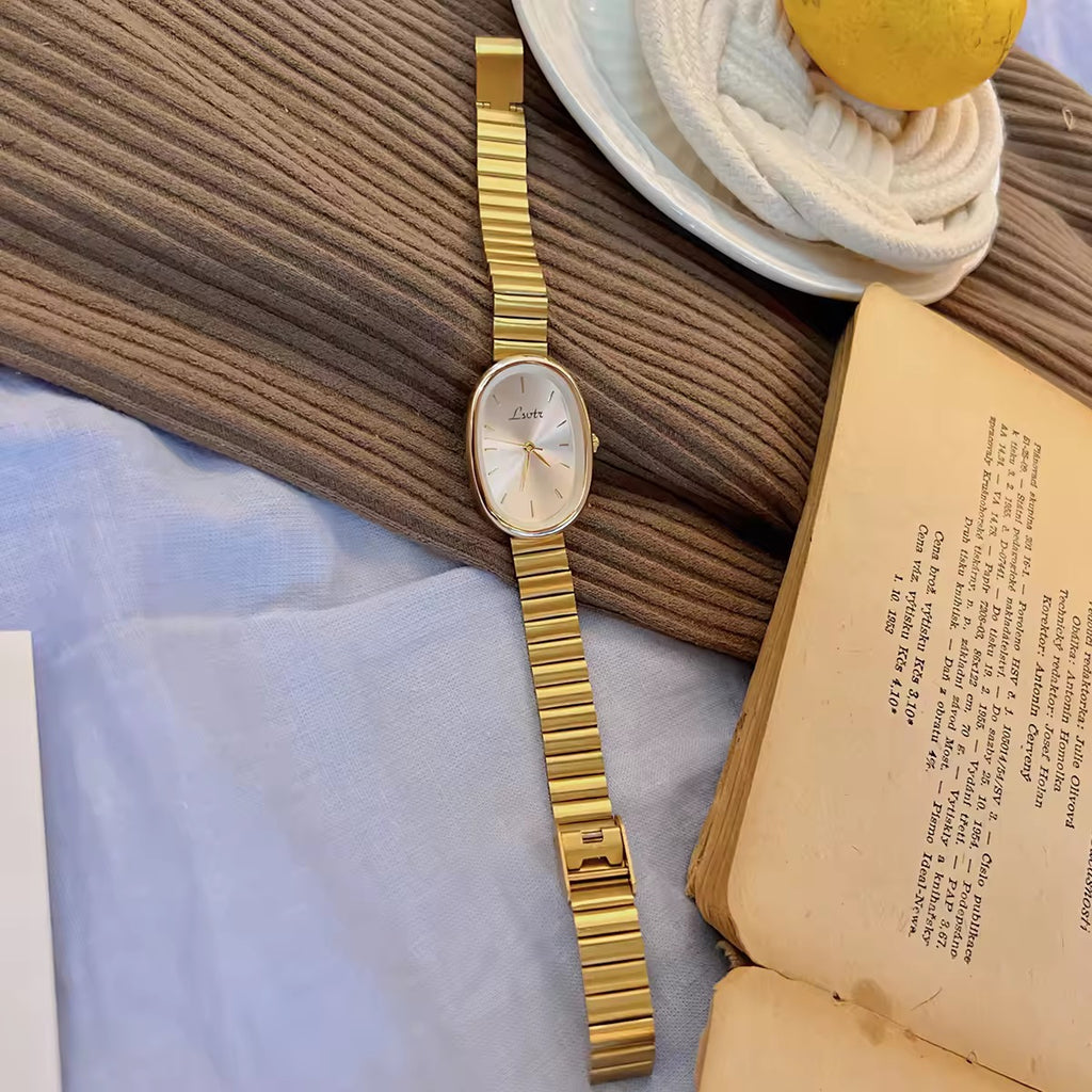 gold minimalist oval dial flex band bracelet watch with sunray silver dial and baton hour markers for women by Le Belle Heure