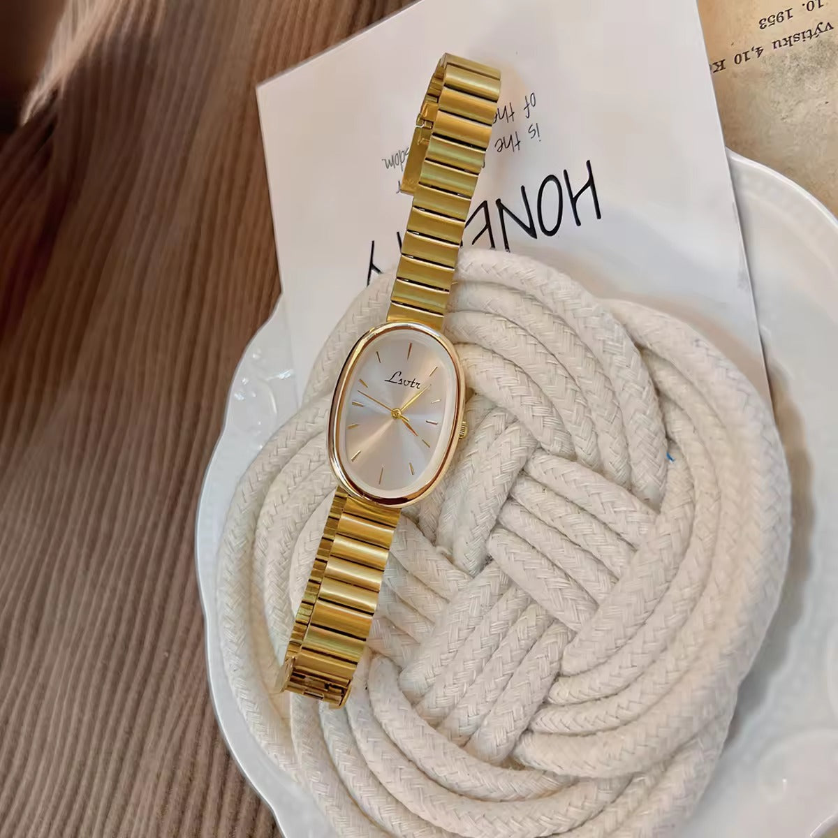 gold minimalist oval dial flex band bracelet watch with sunray silver dial and baton hour markers for women by Le Belle Heure