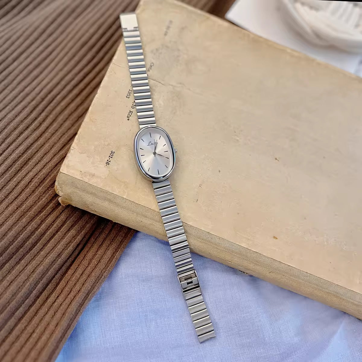 gold minimalist oval dial flex band bracelet watch with sunray silver dial and baton hour markers for women by Le Belle Heure