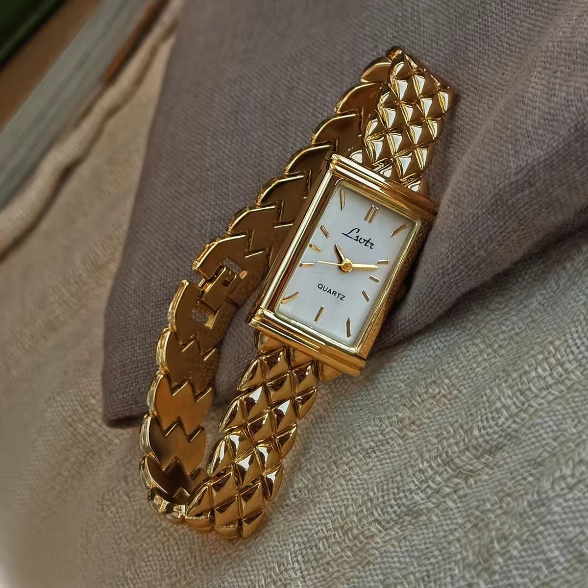 Gold pyramid quilted stud chain wide bracelet watch with white rectangular dial and gold baton hour markers for women by Le Belle Heure