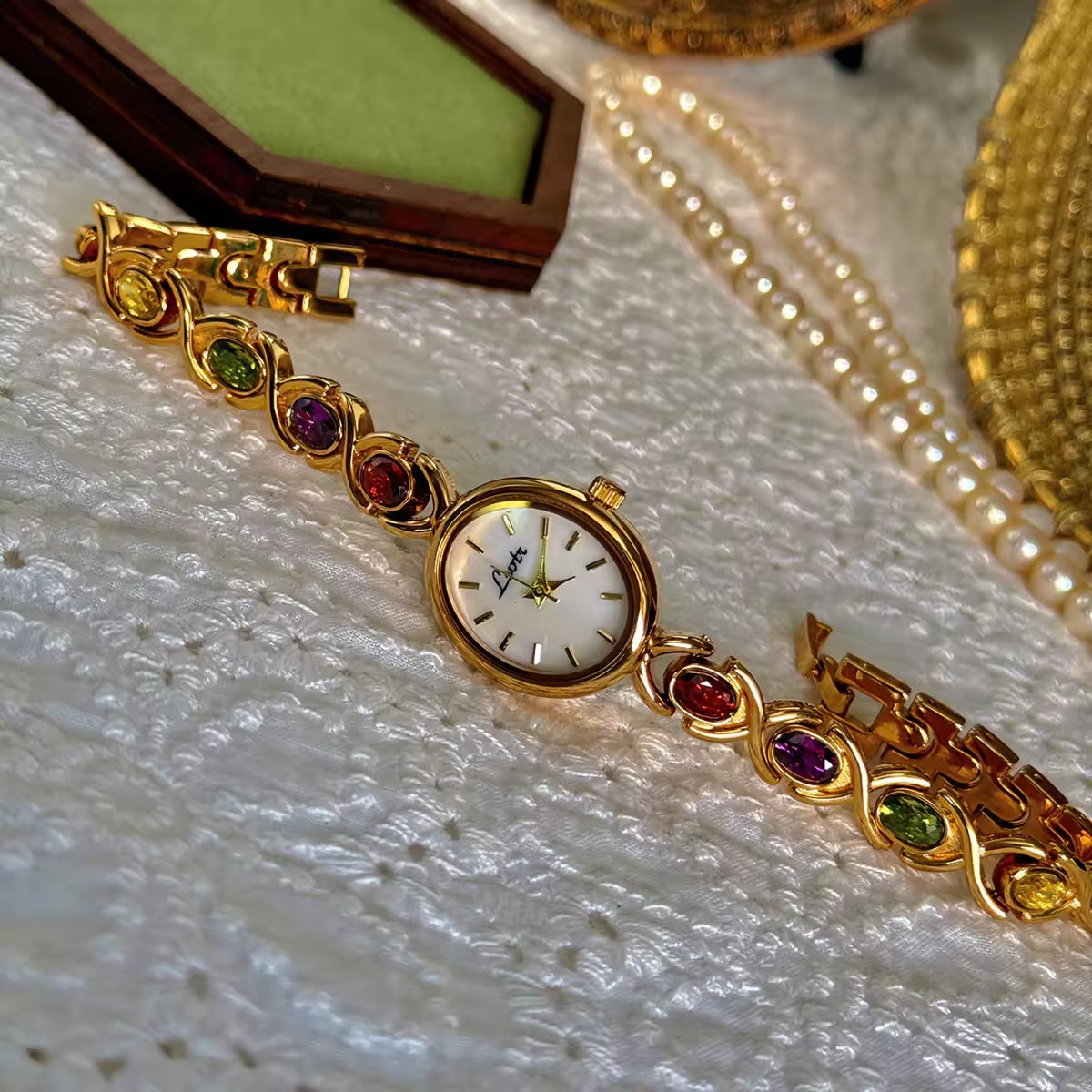 Gold XO link bracelet watch with mother-of-pearl oval dial and multicolour oval gemstones in ruby, amethyst, peridot and citrine for women by Le Belle Heure
