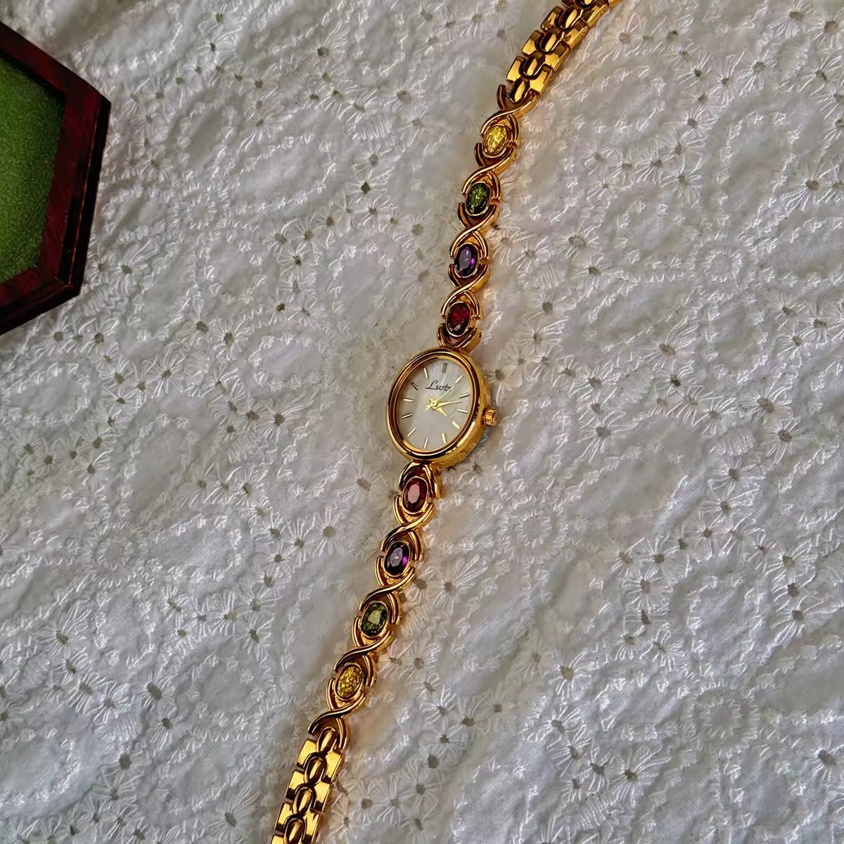 Gold XO link bracelet watch with mother-of-pearl oval dial and multicolour oval gemstones in ruby, amethyst, peridot and citrine for women by Le Belle Heure