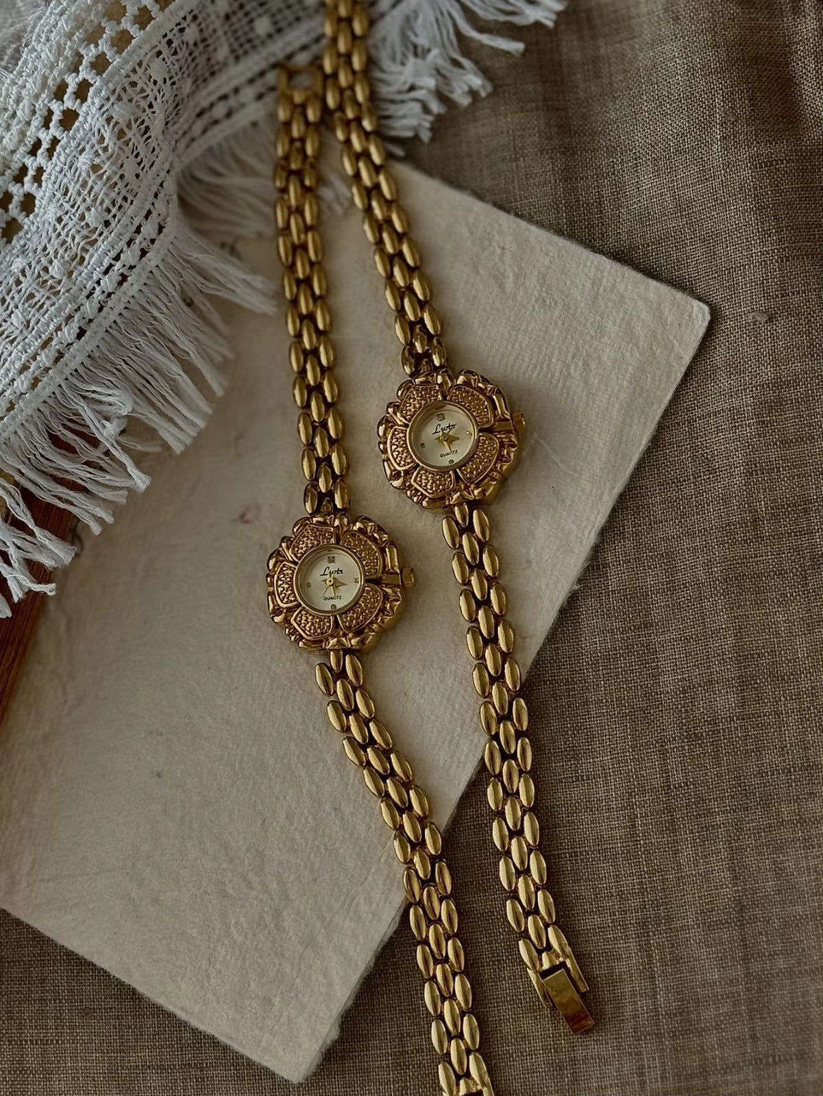 Bold gold-tone panther chain link bracelet band on women’s vintage-style flower watch