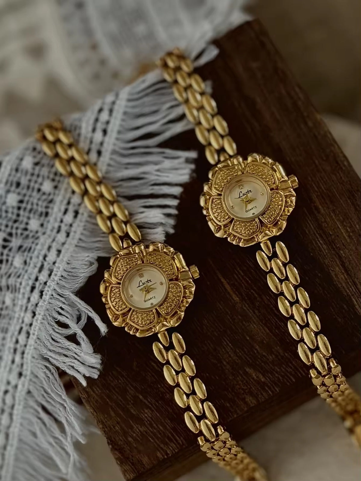 Bold gold-tone panther chain link bracelet band on women’s vintage-style flower watch