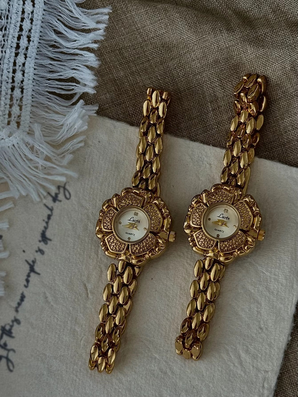 Bold gold-tone panther chain link bracelet band on women’s vintage-style flower watch