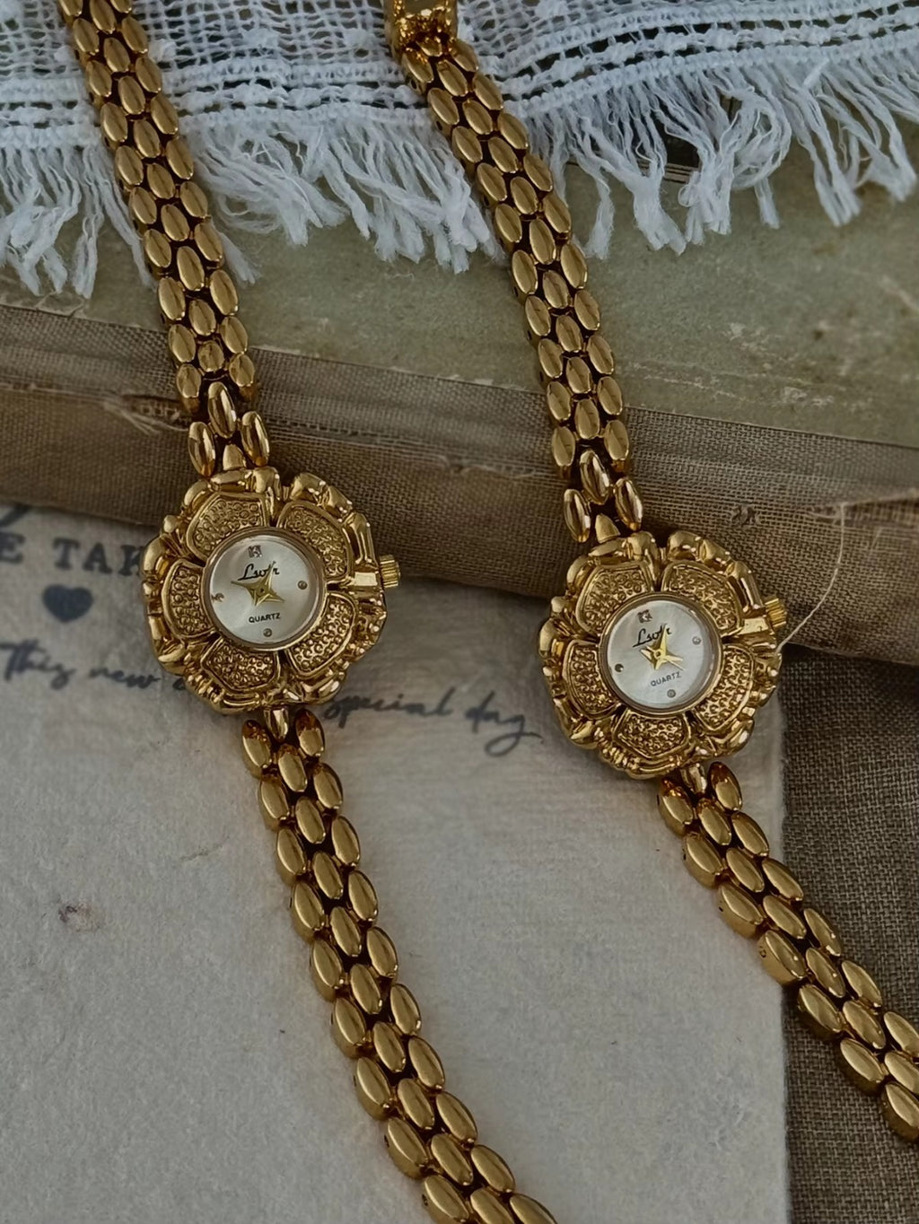 Bold gold-tone panther chain link bracelet band on women’s vintage-style flower watch