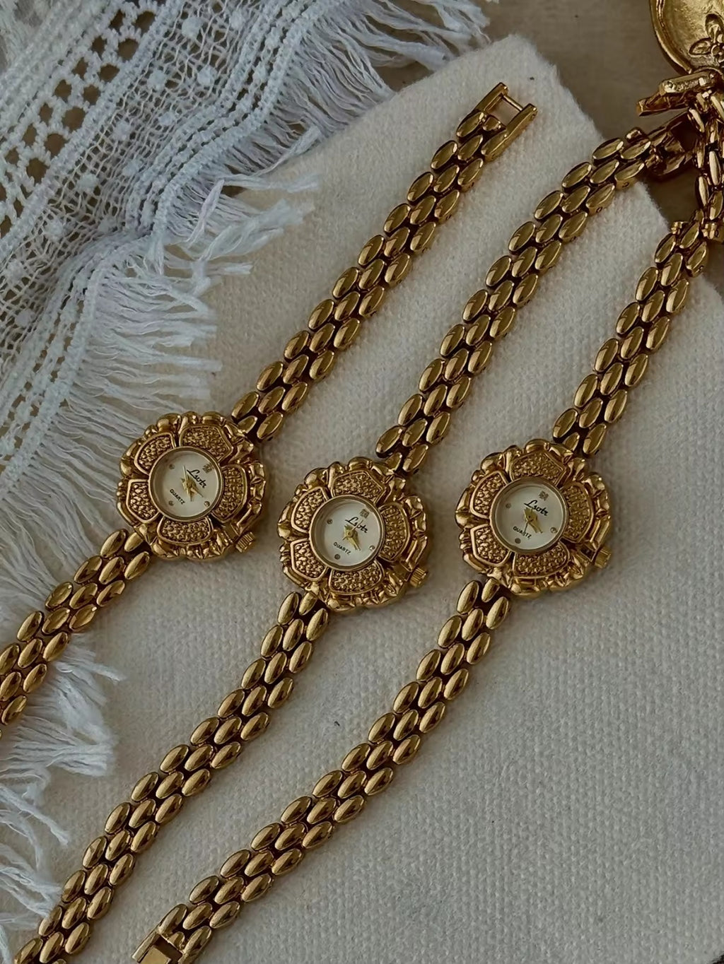 Bold gold-tone panther chain link bracelet band on women’s vintage-style flower watch