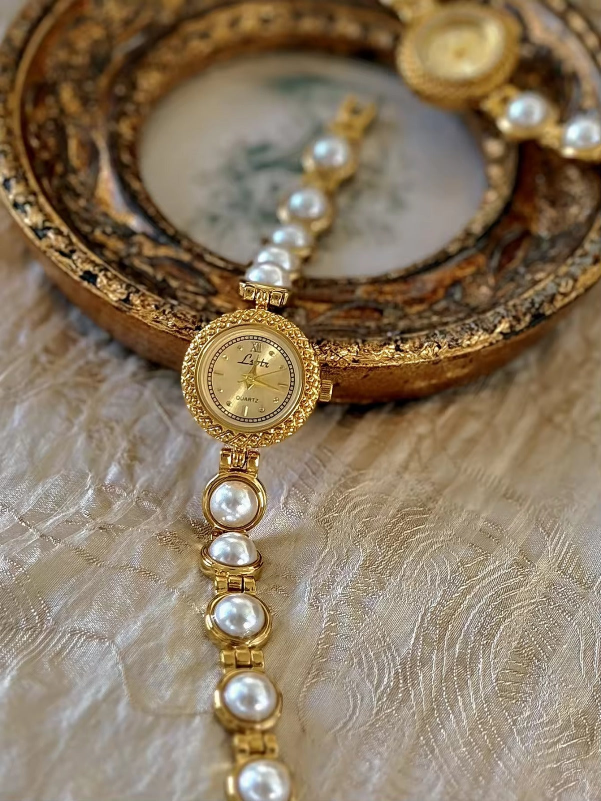 Gold pearl bracelet watch styled on antique gold frame tray – Le Belle Heure women’s watch