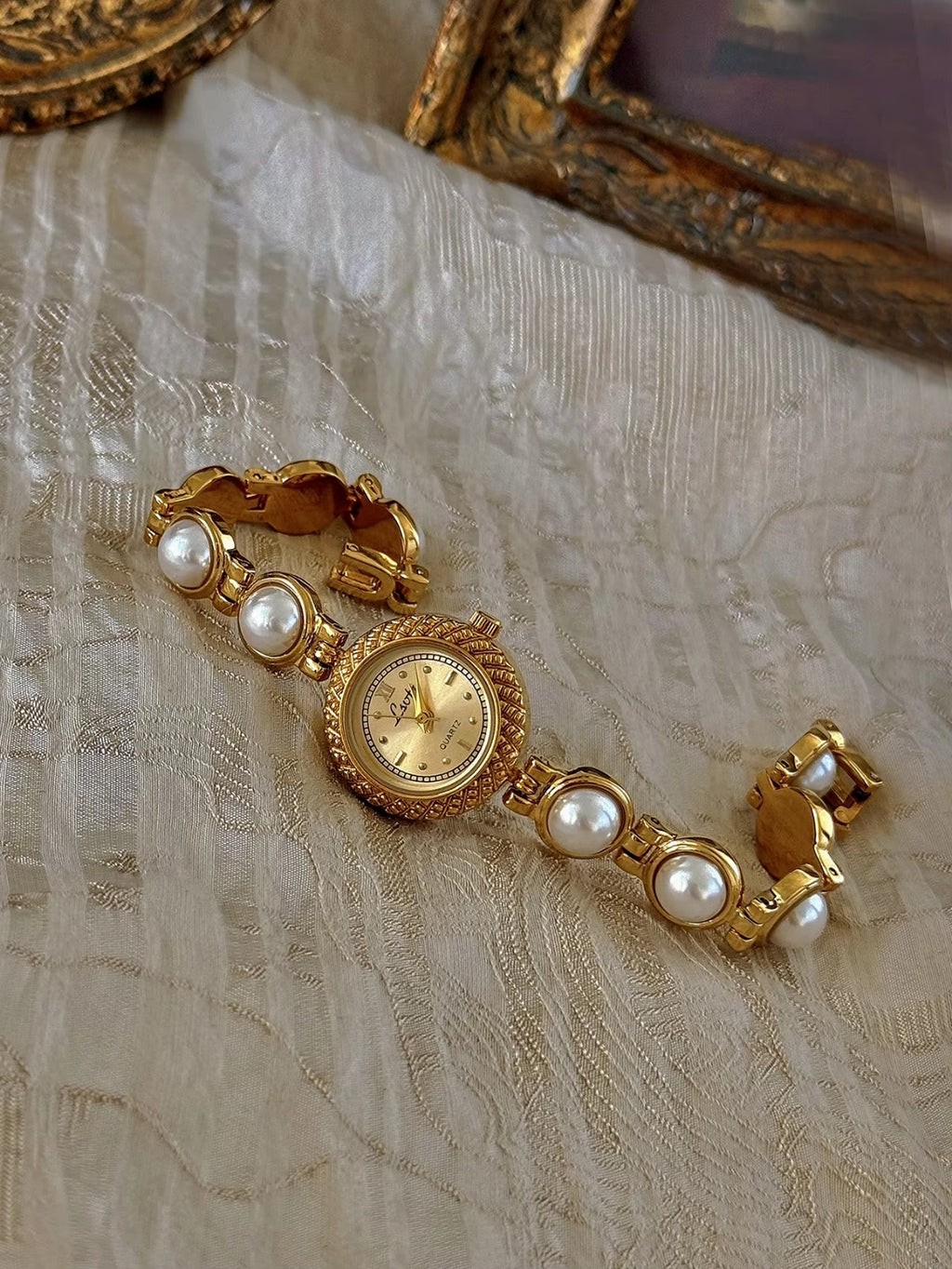 Gold pearl bracelet watch styled on antique gold frame tray – Le Belle Heure women’s watch