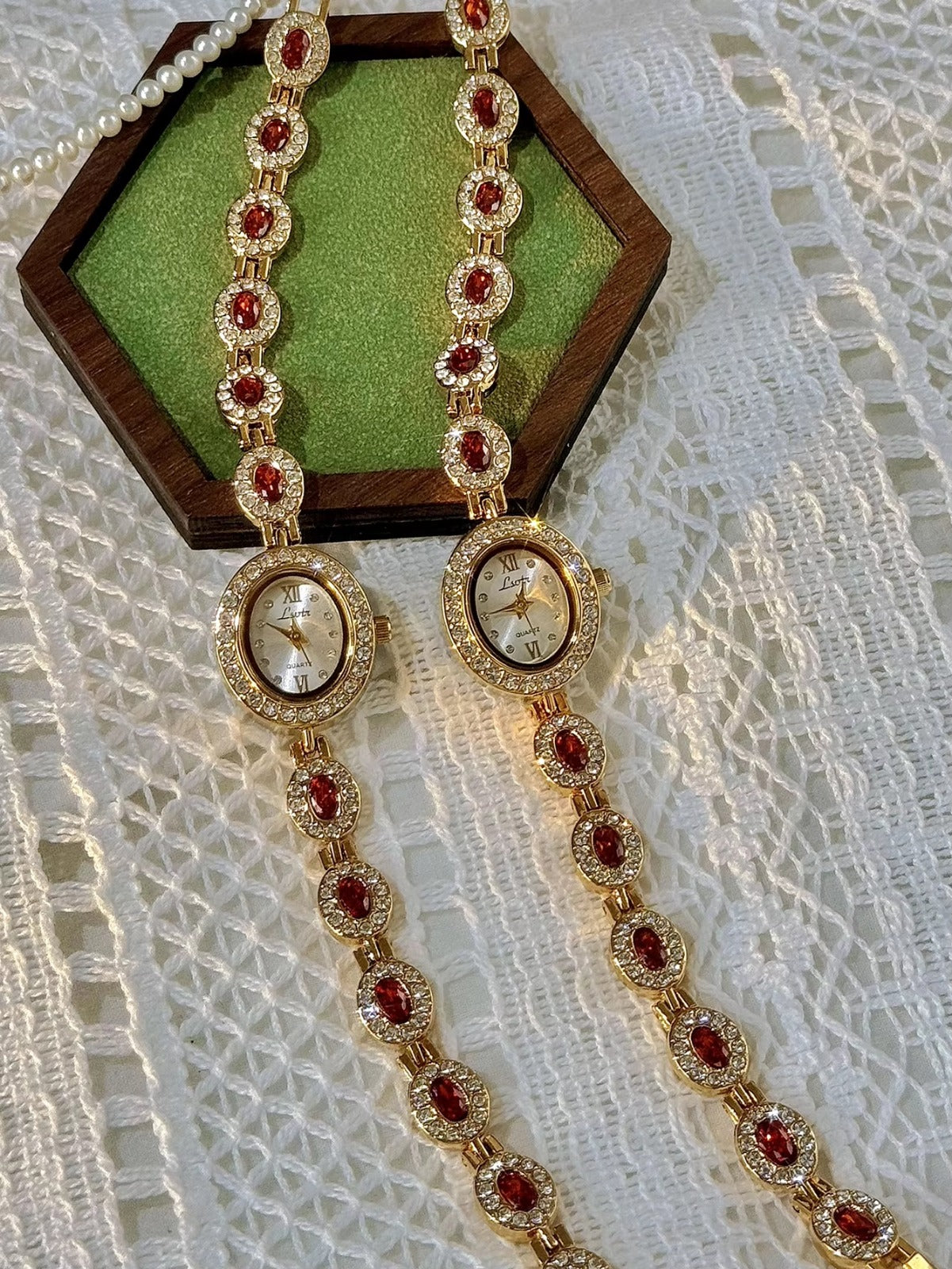 Gold-tone bracelet watch band with ruby-red oval crystals surrounded by white crystal links