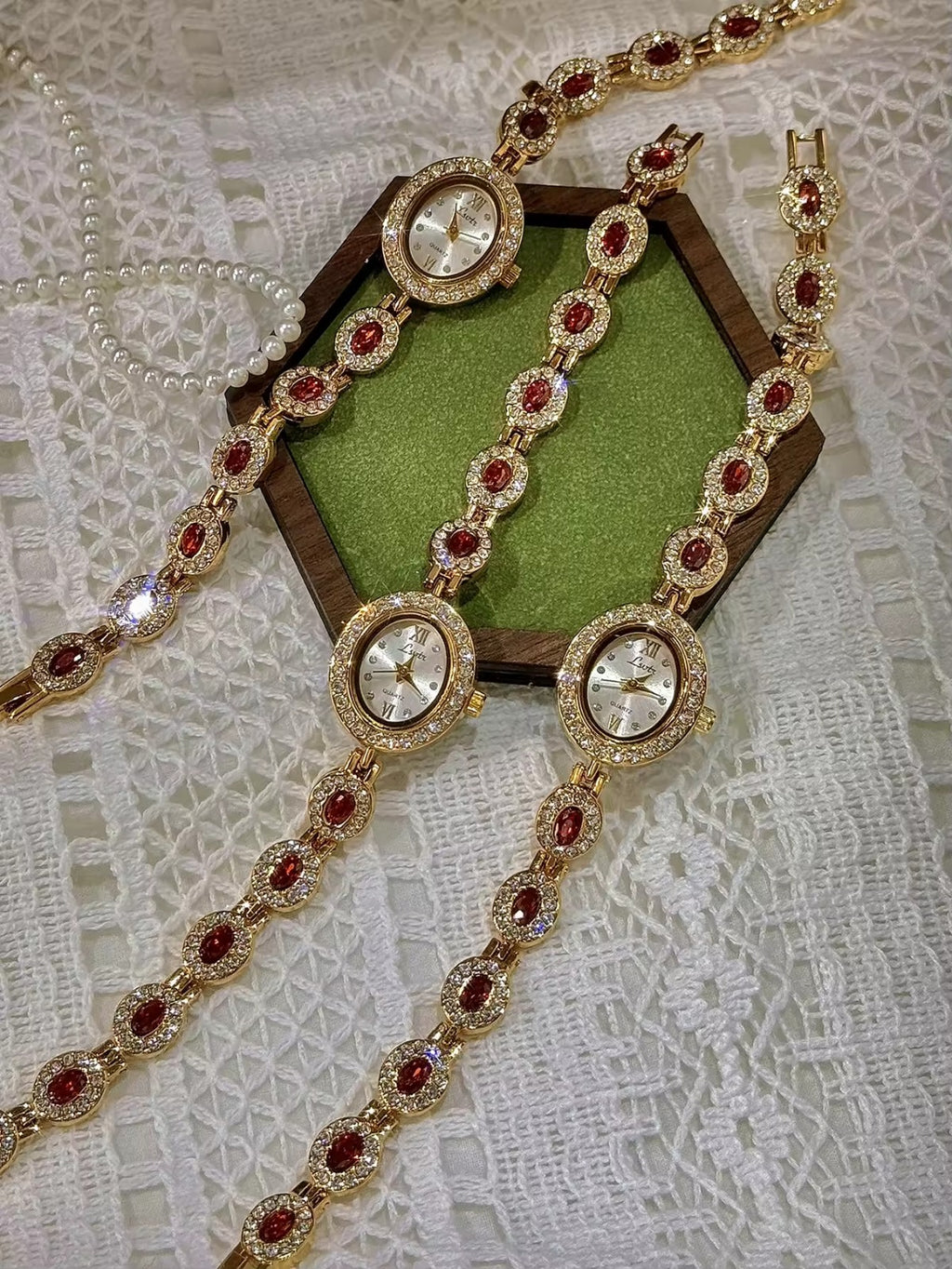 Gold-tone bracelet watch band with ruby-red oval crystals surrounded by white crystal links