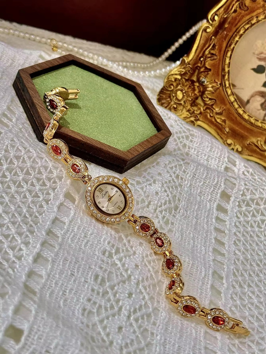Gold-tone bracelet watch band with ruby-red oval crystals surrounded by white crystal links