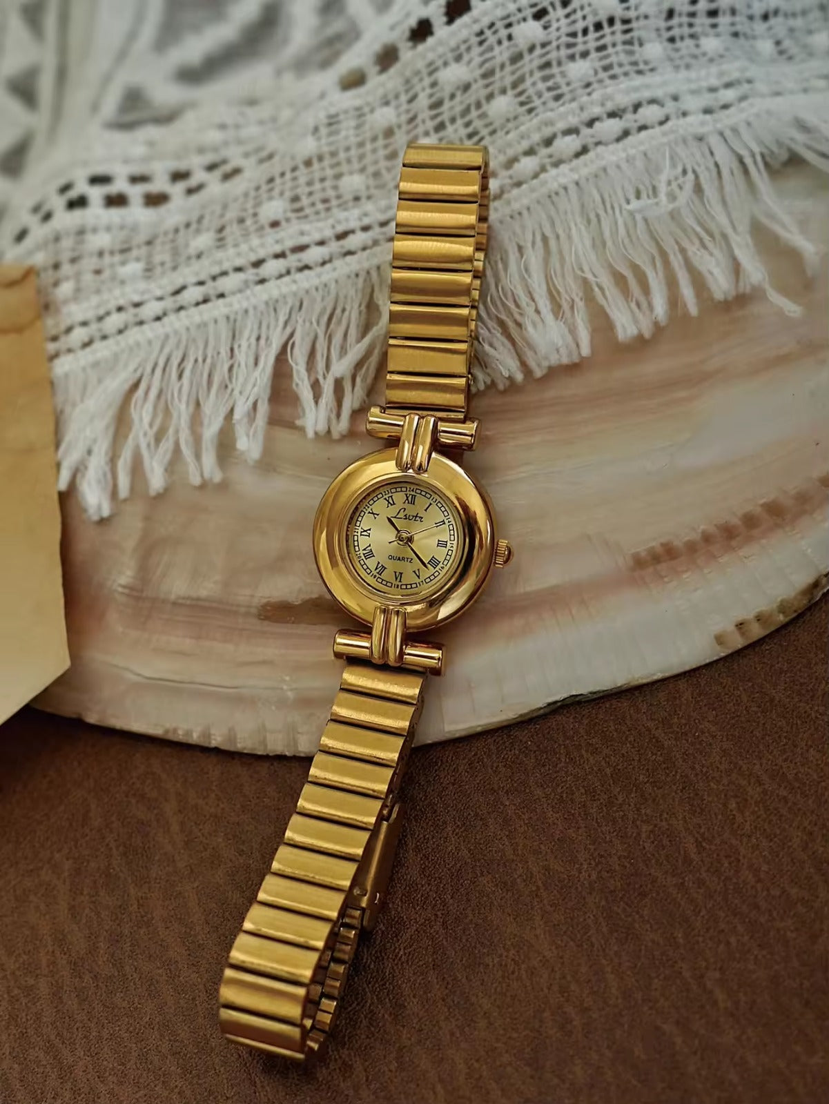 Gold domed oval watch with Roman numeral champagne dial, double
bar lug case connectors and wide ribbed accordion flex band for women by Le Belle Heure