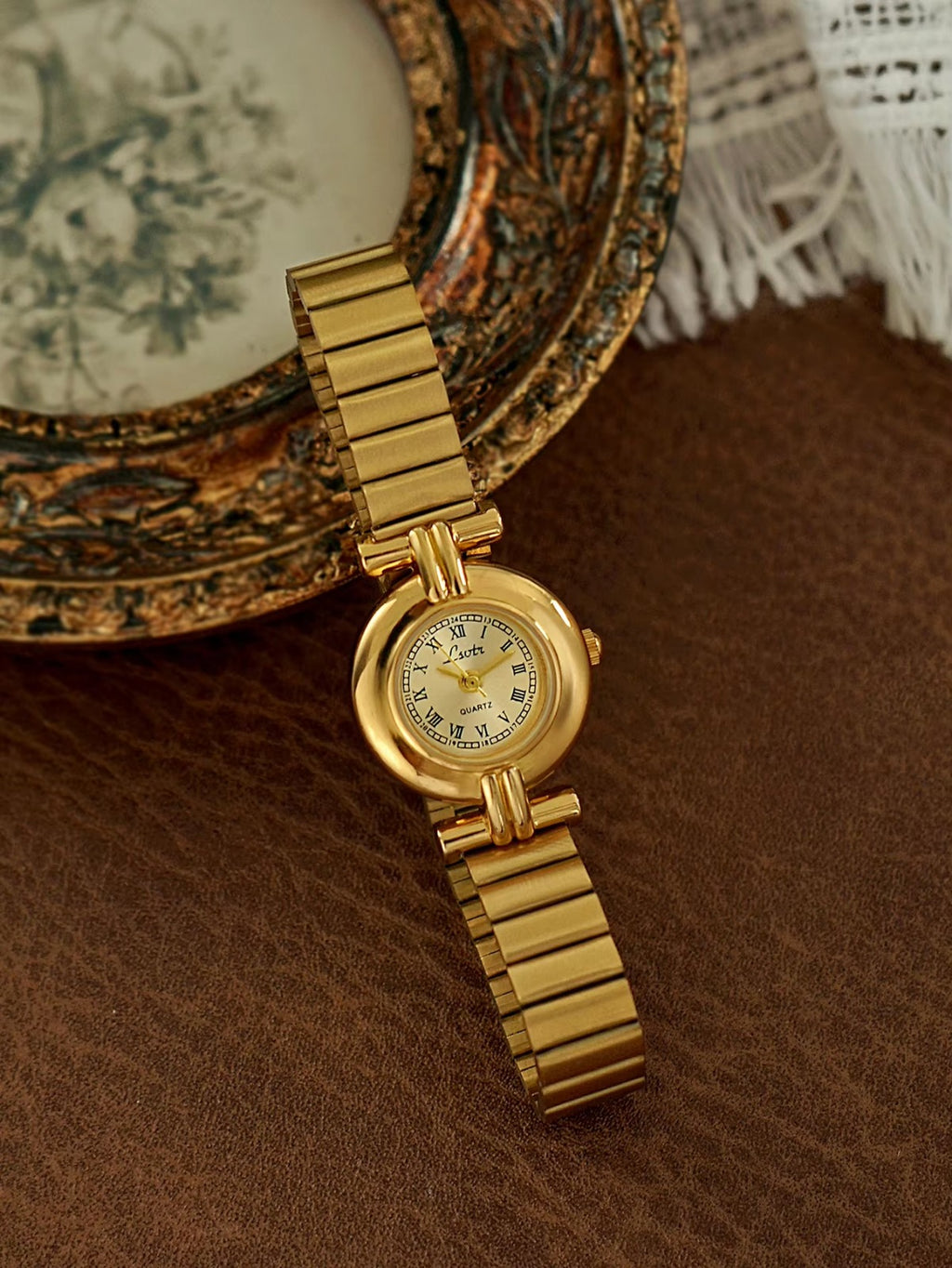 Gold domed oval watch with Roman numeral champagne dial, double
bar lug case connectors and wide ribbed accordion flex band for women by Le Belle Heure
