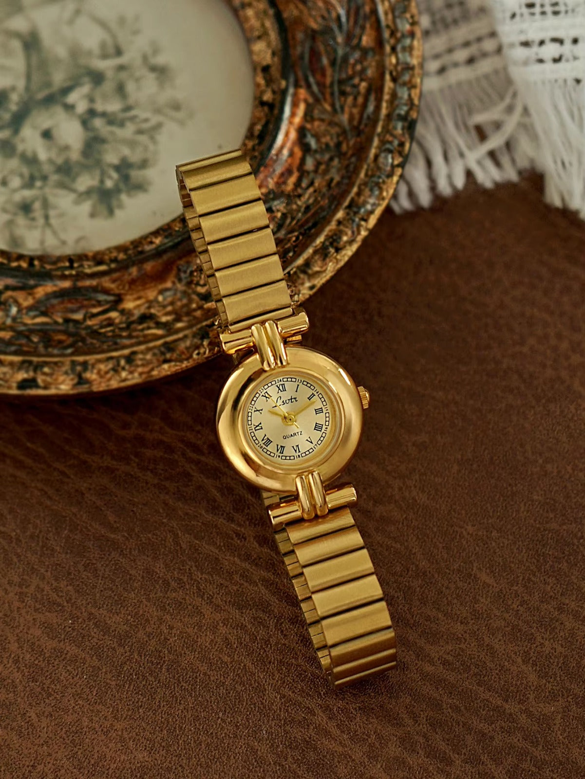 Gold domed oval watch with Roman numeral champagne dial, double
bar lug case connectors and wide ribbed accordion flex band for women by Le Belle Heure