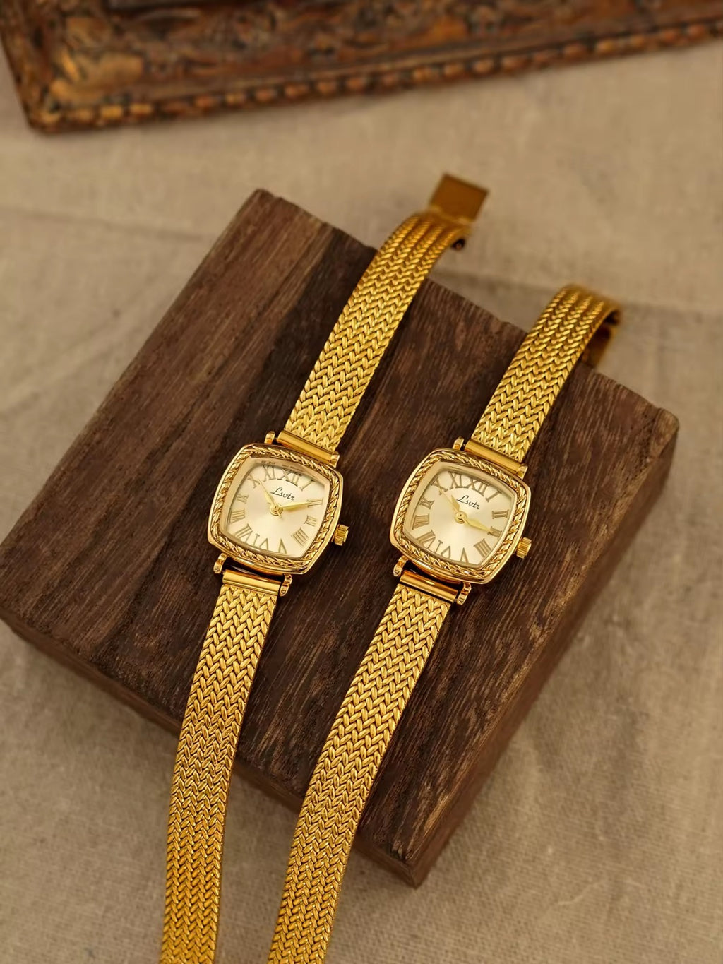 Gold tonneau cushion-shaped watch with engraved rope-twist bezel,
Roman numeral champagne sunburst dial and wide braided herringbone mesh bracelet for women by Le Belle Heure