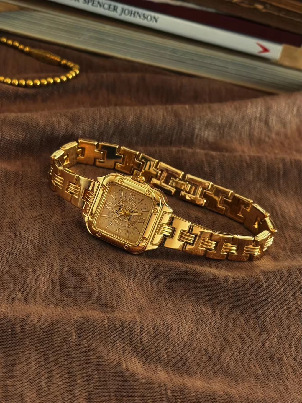 Gold square Roman numeral textured sunburst dial watch with screw
corner accents and wide structured woven link chain bracelet for women by Le Belle Heure