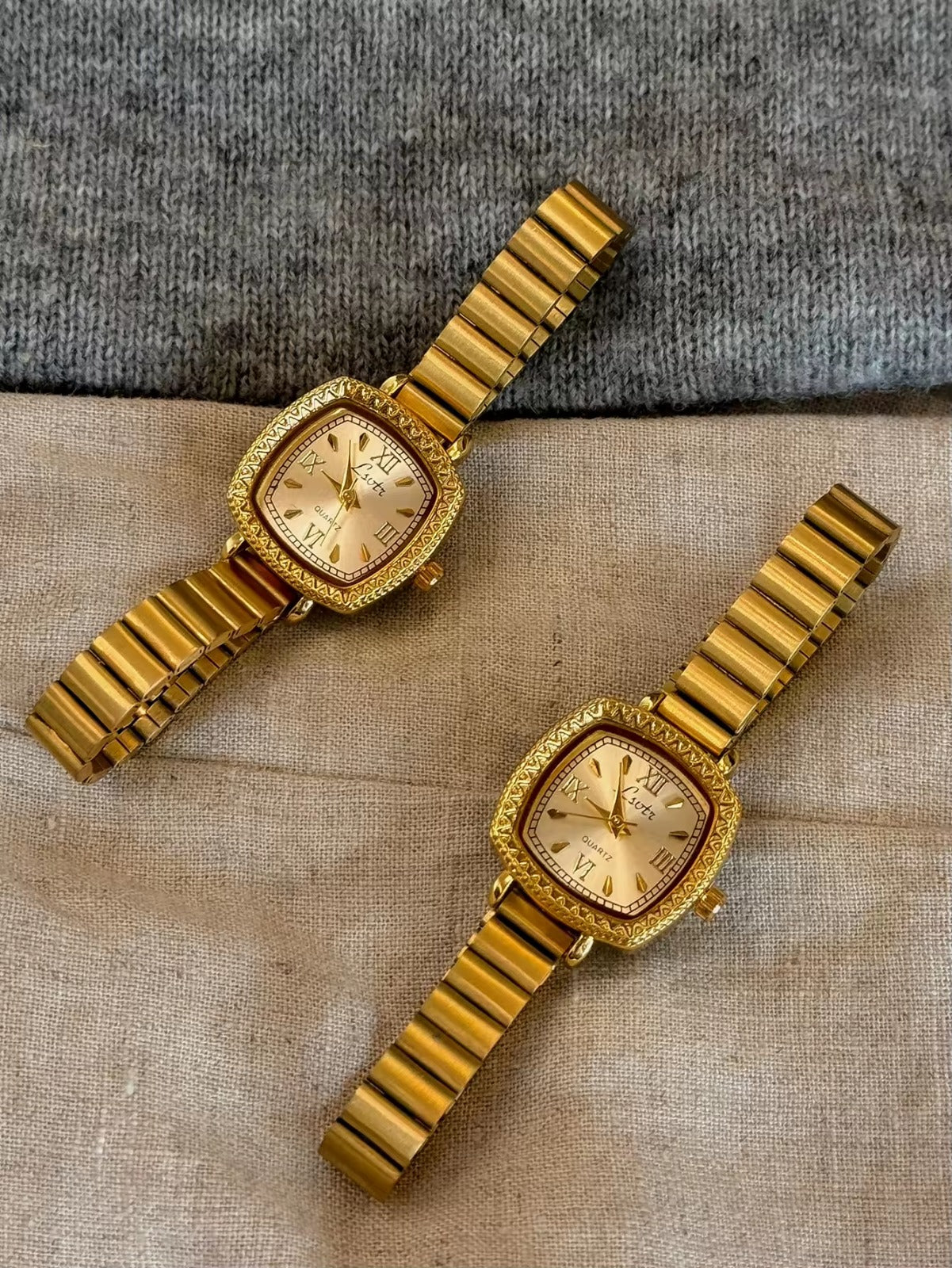 Gold cushion square watch with deeply engraved geometric chevron
bezel, Roman numeral and baton marker champagne dial and structured gold expansion flex bracelet for women by Le Belle Heure